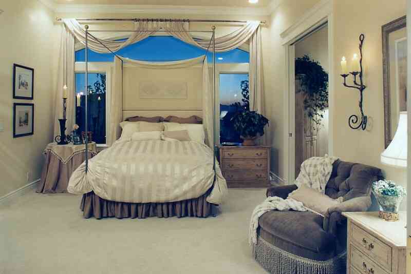 Old-fashion-bedroom-with-light-bed-cover-canopy-bed-and-windows